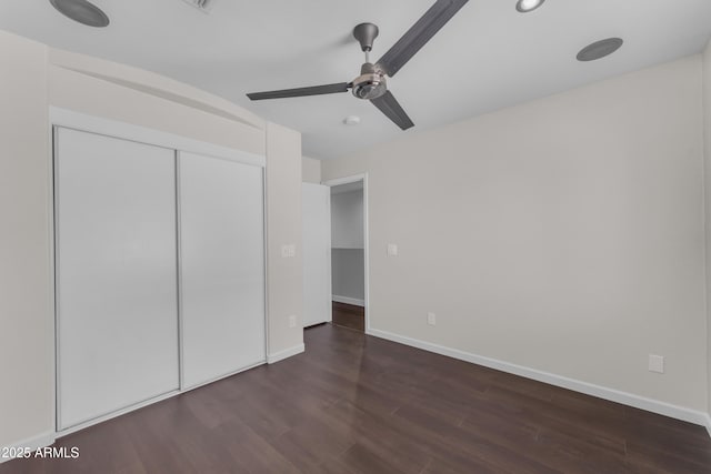 unfurnished bedroom featuring baseboards, a ceiling fan, wood finished floors, and a closet