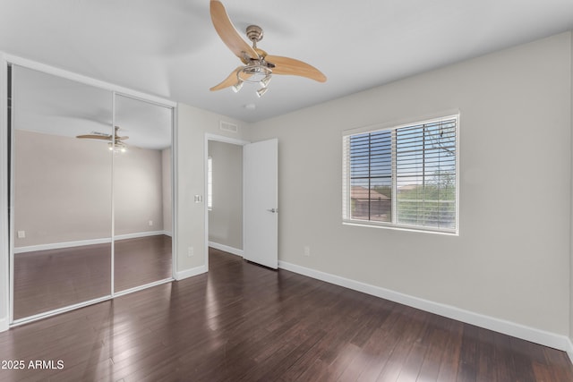 unfurnished bedroom with ceiling fan, baseboards, wood finished floors, visible vents, and a closet