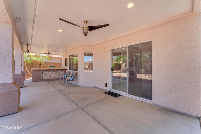 view of patio with ceiling fan and fence
