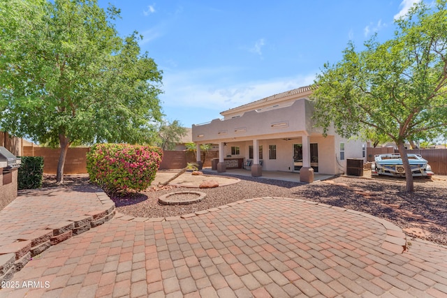 rear view of house with a fenced backyard, a patio area, stucco siding, and cooling unit