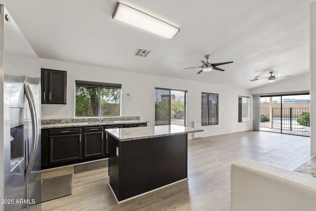 13438 N 130th Ln, El Mirage, AZ 85335 - kitchen with stainless steel fridge with ice dispenser, light wood-style flooring, a center island, open floor plan, and vaulted ceiling