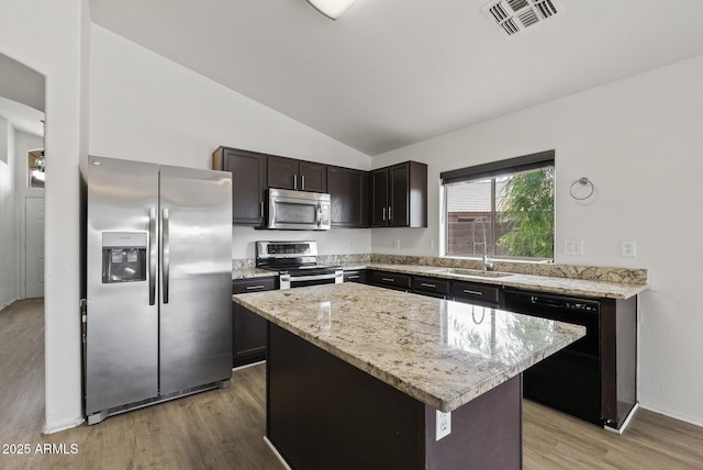 13438 N 130th Ln, El Mirage, AZ 85335 - kitchen featuring stainless steel appliances, a sink, lofted ceiling, light wood-style flooring, and a kitchen island