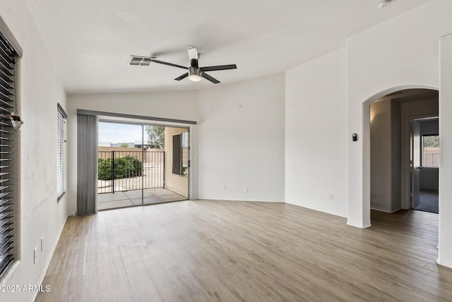 13438 N 130th Ln, El Mirage, AZ 85335 - empty room with ceiling fan, wood finished floors, arched walkways, and lofted ceiling