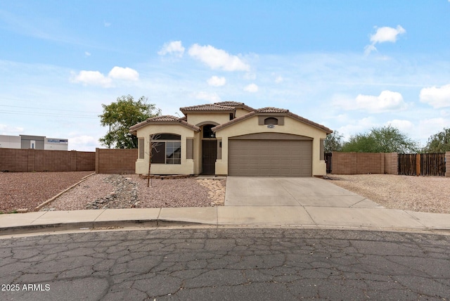 13438 N 130th Ln, El Mirage, AZ 85335 - mediterranean / spanish-style house featuring stucco siding, concrete driveway, a garage, a tiled roof, and a gate