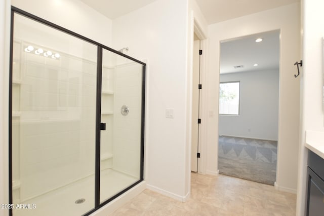 bathroom featuring baseboards, a shower stall, and vanity