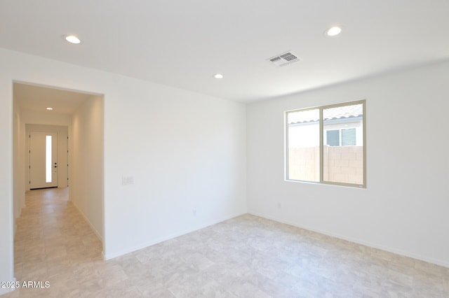 empty room featuring recessed lighting, visible vents, and baseboards