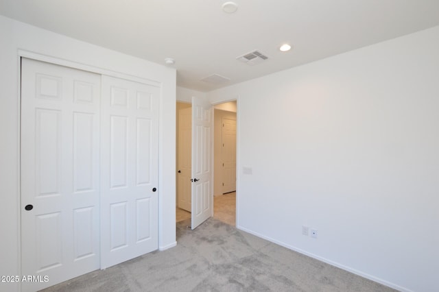 unfurnished bedroom featuring light carpet, baseboards, visible vents, a closet, and recessed lighting