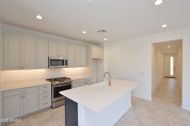 kitchen featuring a center island with sink, stainless steel appliances, recessed lighting, visible vents, and a sink