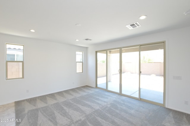 empty room with carpet flooring, visible vents, and recessed lighting