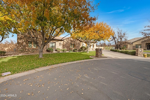 view of front of home featuring a residential view, driveway, and a front yard