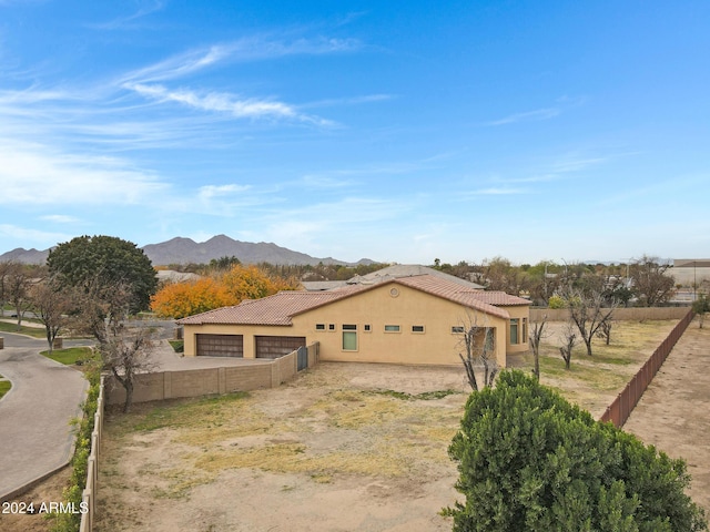 exterior space featuring a tiled roof, fence, a mountain view, and stucco siding