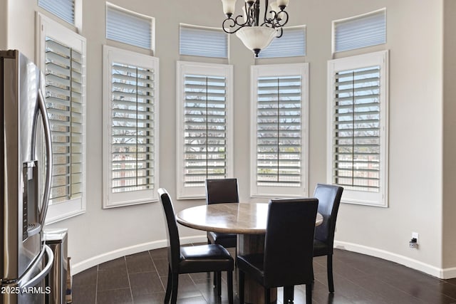 dining area featuring a notable chandelier and baseboards