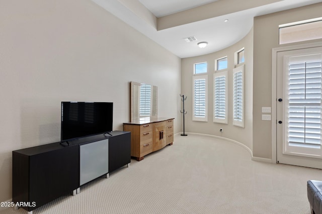 interior space featuring baseboards, visible vents, and light colored carpet