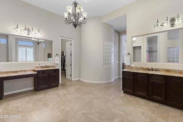 full bathroom with two vanities, a sink, baseboards, and an inviting chandelier