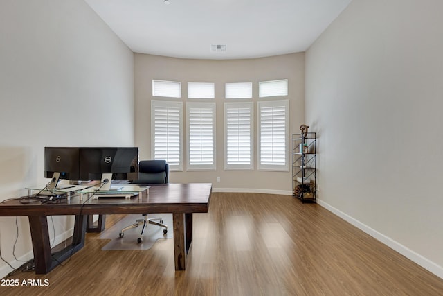 office featuring light wood-type flooring, visible vents, and baseboards