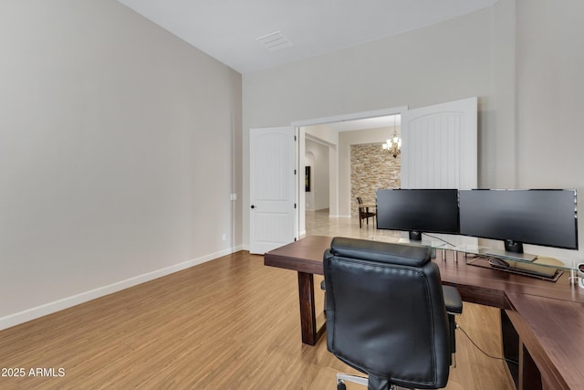 office featuring light wood-style floors, baseboards, and an inviting chandelier