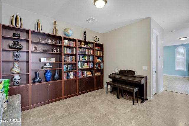 living area with baseboards and visible vents