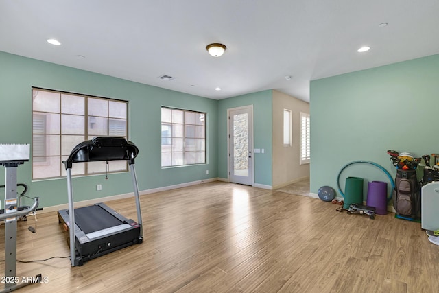 exercise room with recessed lighting, light wood-style flooring, and baseboards