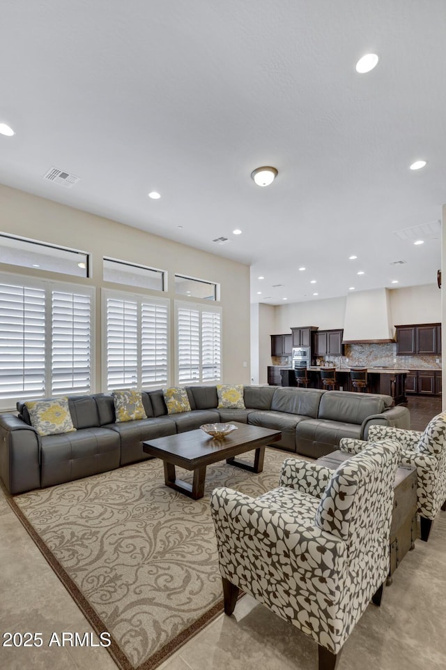 living area featuring visible vents and recessed lighting