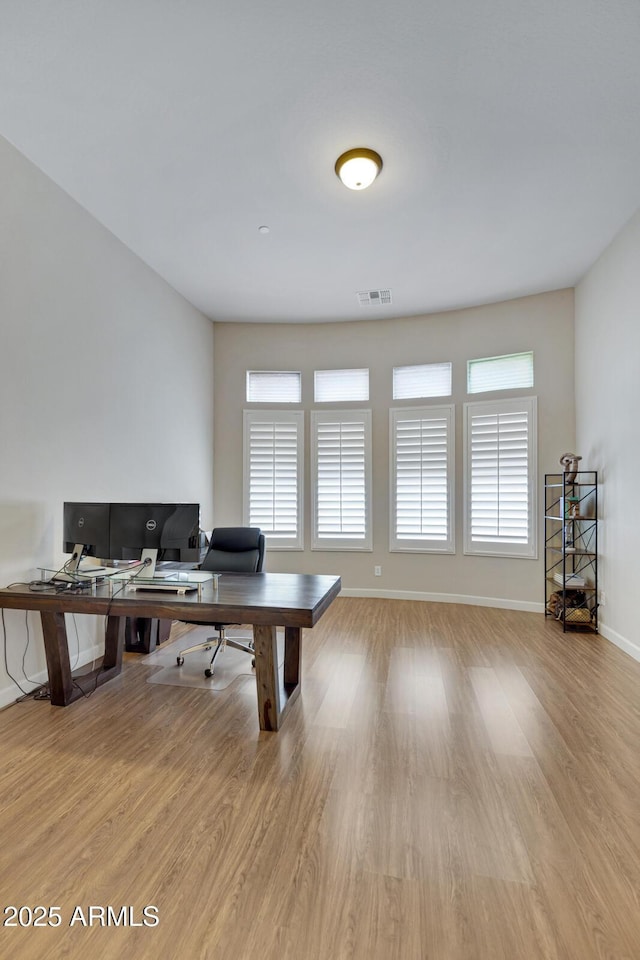 office area featuring a wealth of natural light, visible vents, and light wood-style flooring