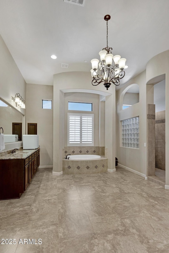 bathroom featuring vanity, walk in shower, a garden tub, and visible vents