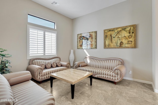 living room featuring baseboards and visible vents