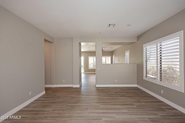 empty room with visible vents, baseboards, and wood tiled floor