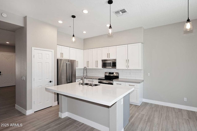 kitchen featuring a sink, stainless steel appliances, backsplash, and visible vents
