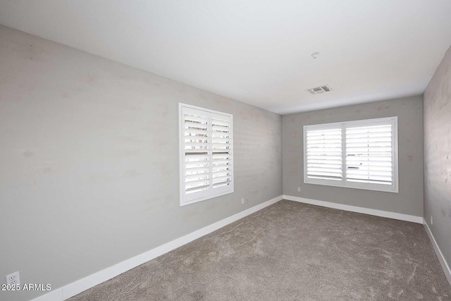 unfurnished room featuring visible vents, carpet flooring, and baseboards