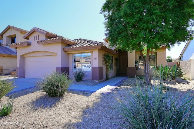 view of front of house with stucco siding, driveway, an attached garage, and a tile roof