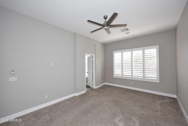 spare room featuring baseboards, visible vents, carpet floors, and ceiling fan