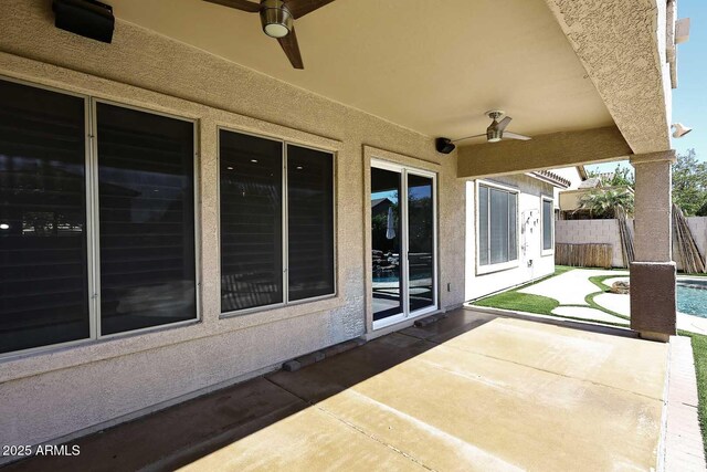 view of patio featuring an outdoor pool, ceiling fan, and fence