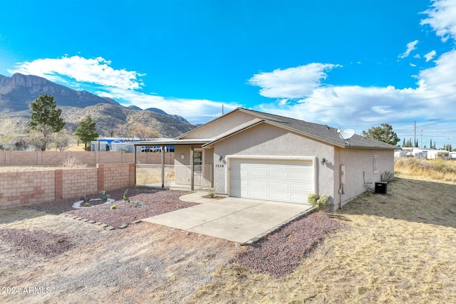 view of front of home with a mountain view, a garage, and central air condition unit