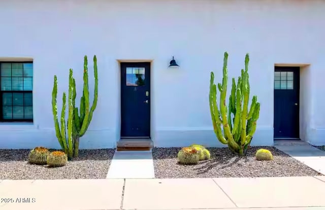 doorway to property featuring stucco siding