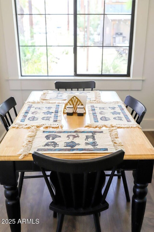 dining space featuring baseboards and wood finished floors