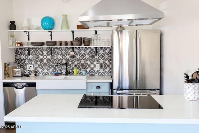 kitchen featuring tasteful backsplash, light countertops, appliances with stainless steel finishes, and range hood