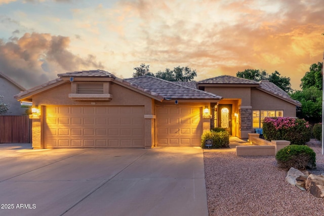 6918 W Villa Hermosa W, Glendale, AZ 85310 - view of front of property featuring concrete driveway, an attached garage, stucco siding, a tile roof, and stone siding