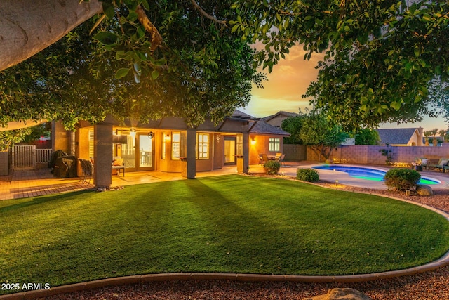 6918 W Villa Hermosa W, Glendale, AZ 85310 - back of property at dusk with a patio, a fenced backyard, and stucco siding