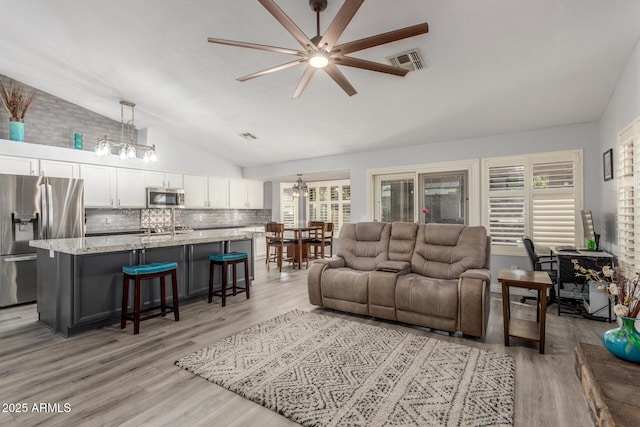 6918 W Villa Hermosa W, Glendale, AZ 85310 - living room with vaulted ceiling, ceiling fan, a chandelier, and light wood-type flooring