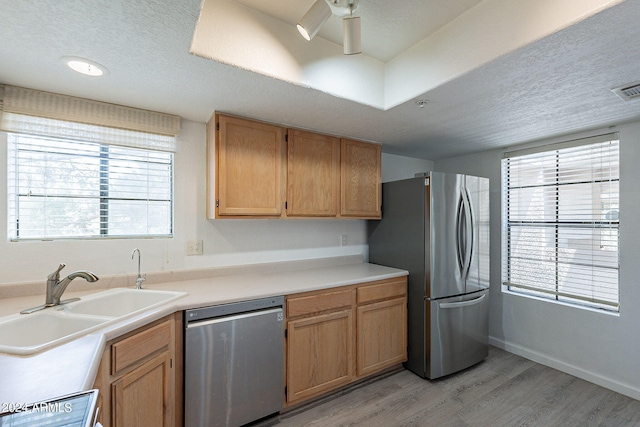 kitchen featuring ceiling fan, light wood-type flooring, sink, a textured ceiling, and stainless steel appliances