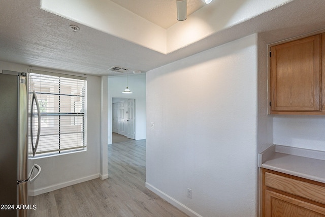 hallway featuring light wood-type flooring and a textured ceiling