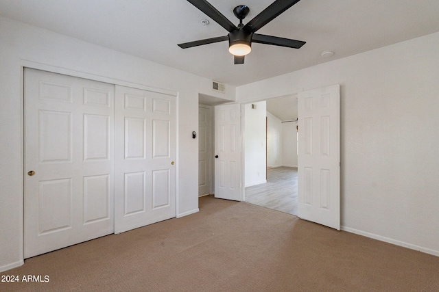 unfurnished bedroom featuring light colored carpet, a closet, and ceiling fan