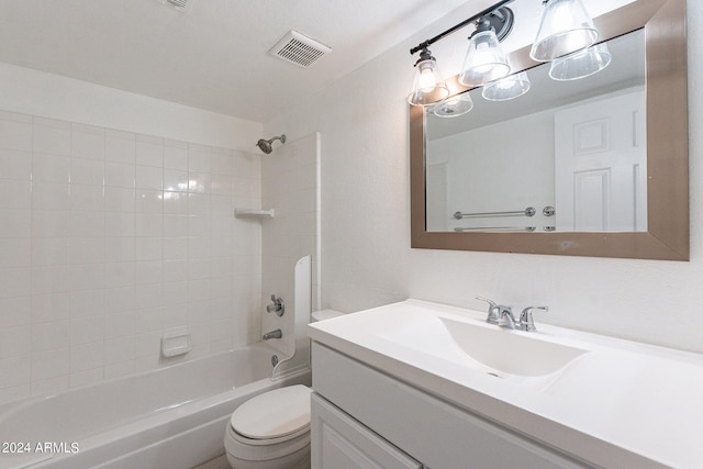 full bathroom featuring tiled shower / bath, toilet, and vanity