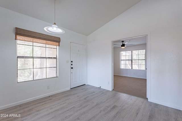 foyer with ceiling fan, high vaulted ceiling, and light carpet