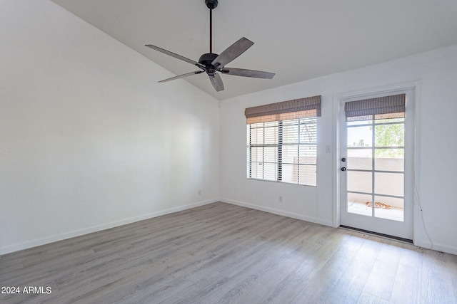 empty room featuring ceiling fan, vaulted ceiling, and light wood-type flooring