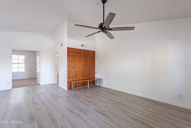 unfurnished living room featuring ceiling fan, high vaulted ceiling, and wood-type flooring