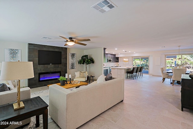 living room with a fireplace and ceiling fan