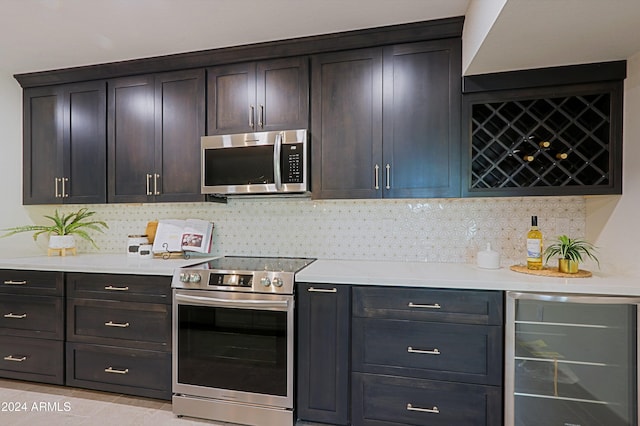 kitchen featuring backsplash, wine cooler, light tile patterned floors, appliances with stainless steel finishes, and dark brown cabinetry