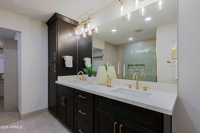 bathroom with tile patterned floors, vanity, and a tile shower