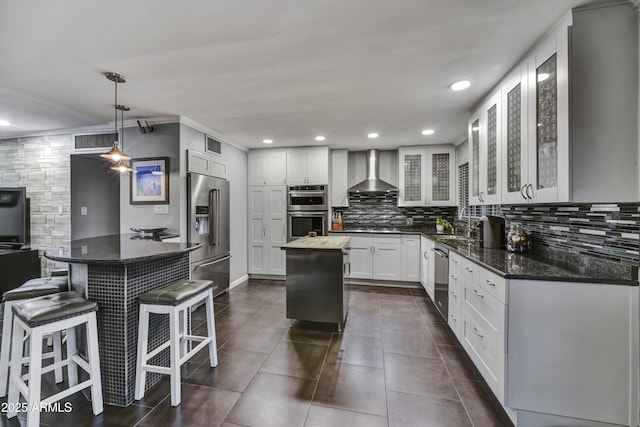 4610 N 14th Ave, Phoenix, AZ 85013 - kitchen with appliances with stainless steel finishes, wall chimney range hood, tasteful backsplash, recessed lighting, and white cabinets